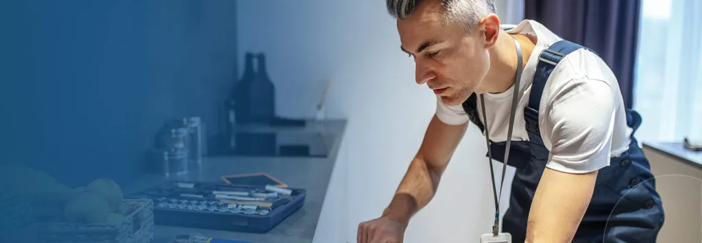 Appliance repair technician working in a kitchen