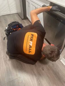Fix It All Masters technician beside an opened washing machine