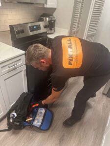 Fix It All Masters technician servicing a household appliance